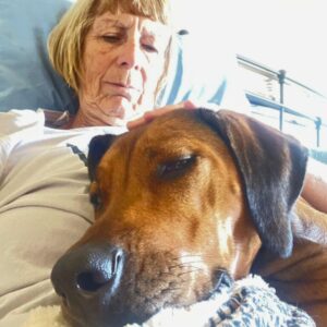 Jennifer resting quietly with her dog during a Pet Meditation Circle, both appearing calm and relaxed together
